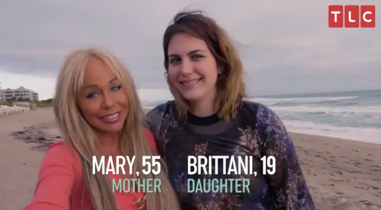 A close mother and daughter in Florida, smiling together near the ocean.