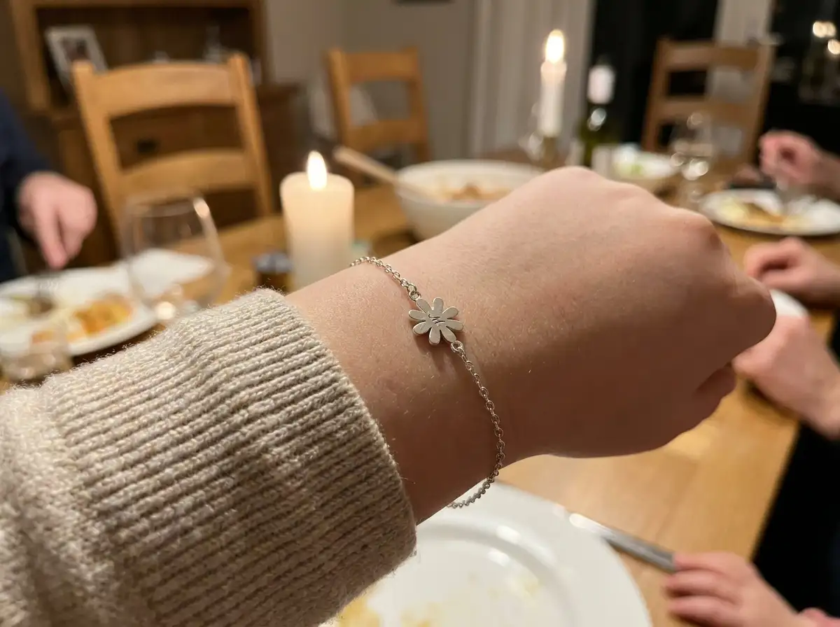 Close up of a silver bracelet with a flower charm on a girl's wrist