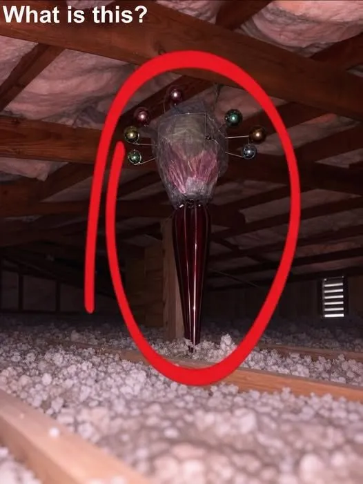 A dusty attic where a coat on a stand casts a shadow that looks like a person