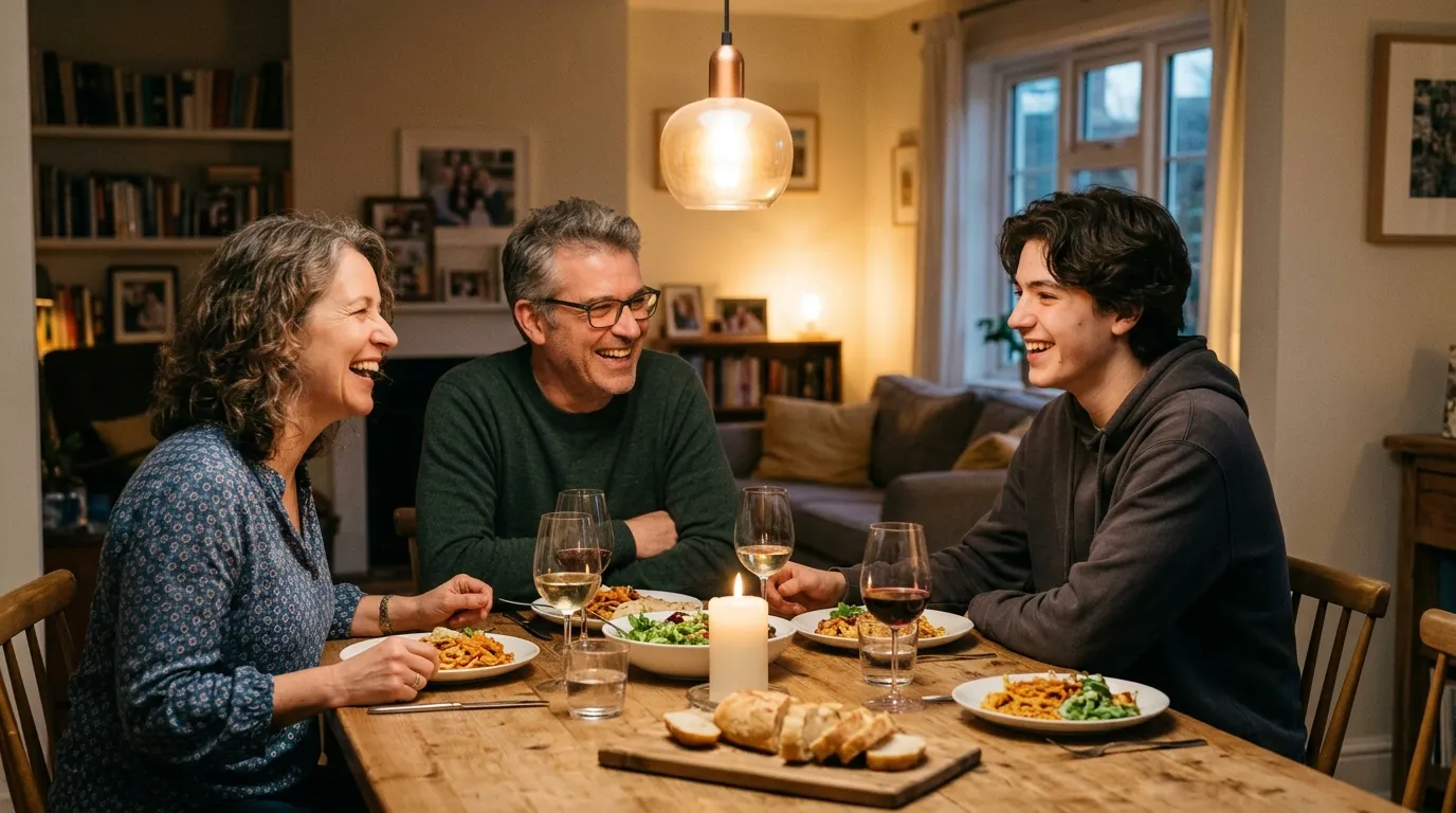A family sharing a meal and laughing together at a cozy dining table.