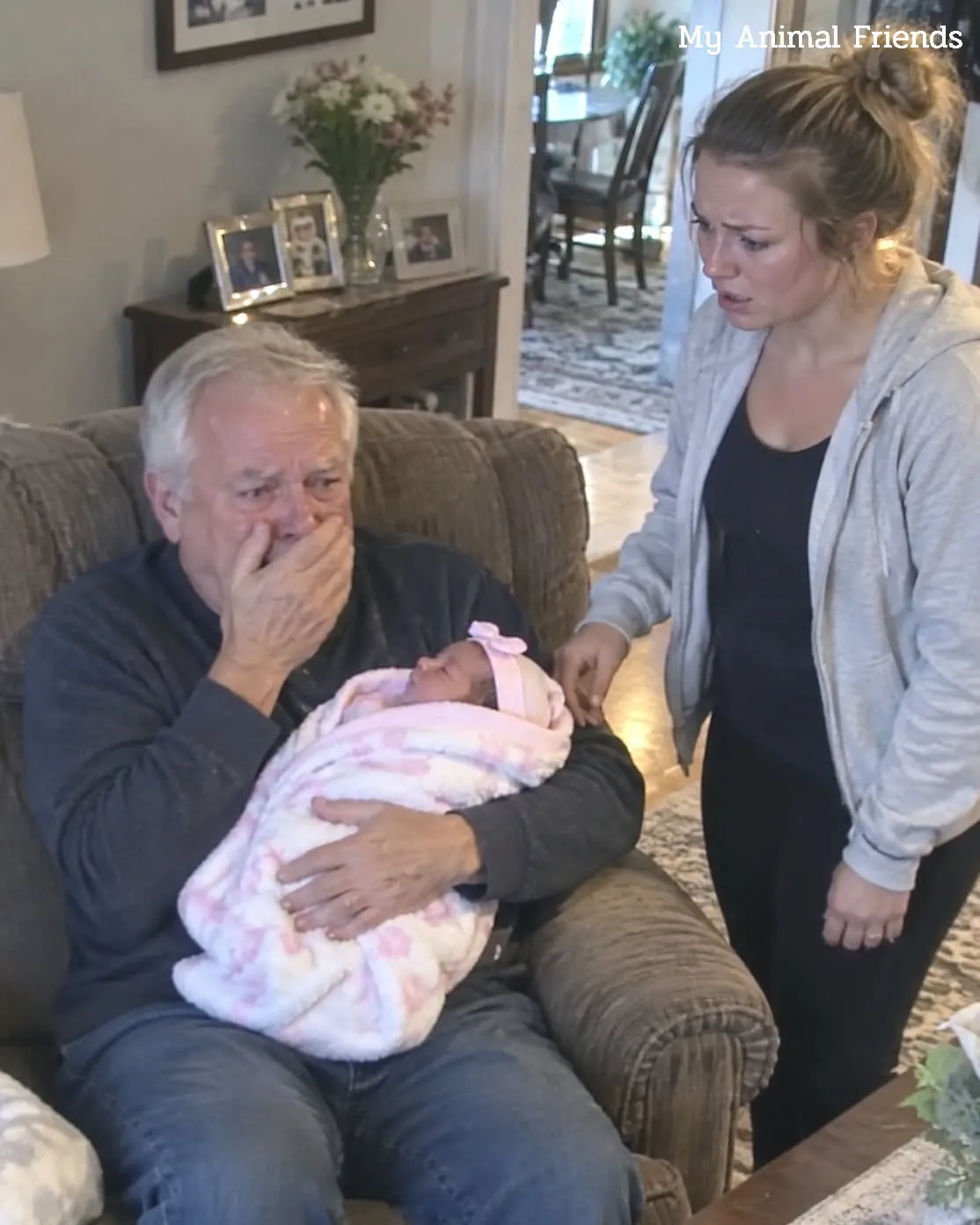 Grandfather looking at a newborn baby on a porch